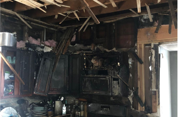 Kitchen showing damage caused by fire.
